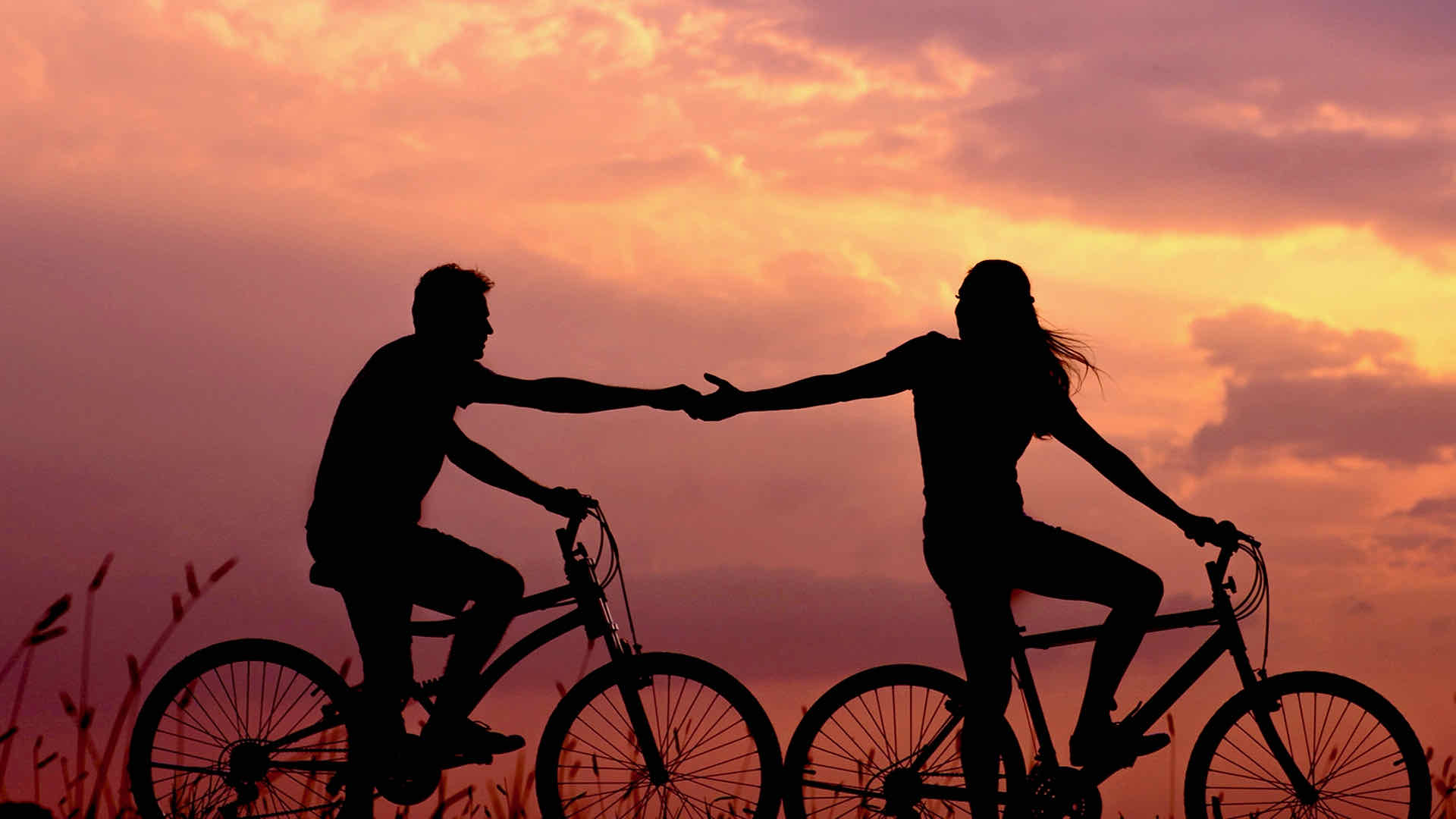 Holding hands on bicycle