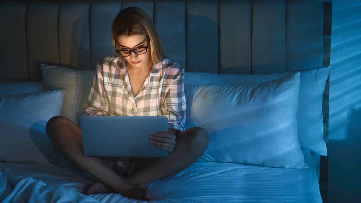 Woman at laptop in bed